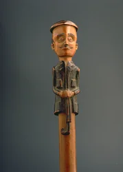 Ficar com uma figura de um homem Europeu, de boné e segurando um guarda-chuva, Ovimbundu, Angola, final do século 19 (madeira)